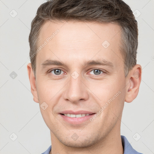 Joyful white young-adult male with short  brown hair and grey eyes