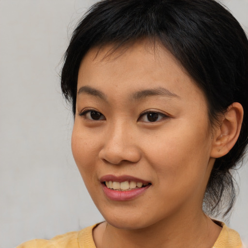 Joyful asian young-adult female with medium  brown hair and brown eyes