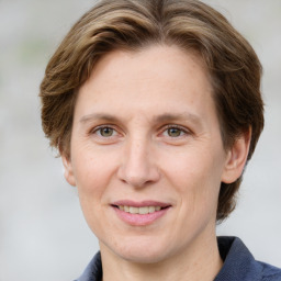 Joyful white adult female with medium  brown hair and grey eyes