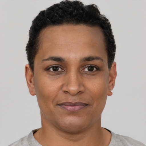 Joyful black young-adult female with short  black hair and brown eyes