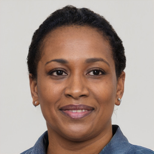 Joyful black adult female with short  black hair and brown eyes
