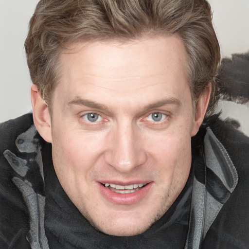 Joyful white adult male with short  brown hair and blue eyes