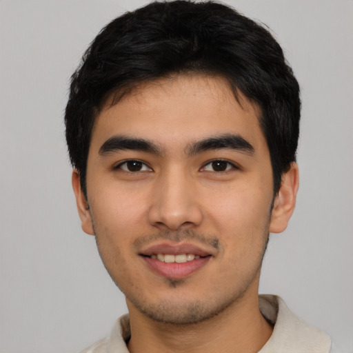Joyful asian young-adult male with short  black hair and brown eyes