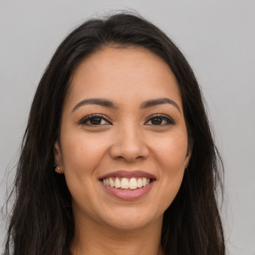 Joyful latino young-adult female with long  brown hair and brown eyes