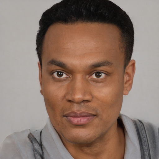 Joyful black young-adult male with short  black hair and brown eyes