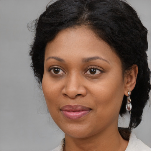 Joyful black adult female with medium  brown hair and brown eyes