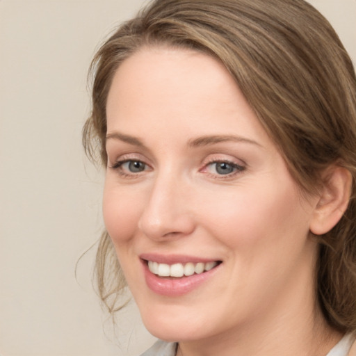 Joyful white young-adult female with medium  brown hair and green eyes