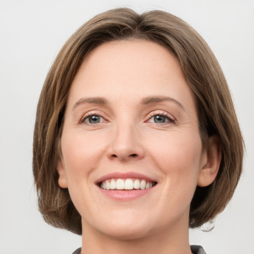 Joyful white young-adult female with medium  brown hair and green eyes