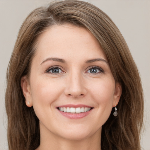 Joyful white young-adult female with long  brown hair and grey eyes