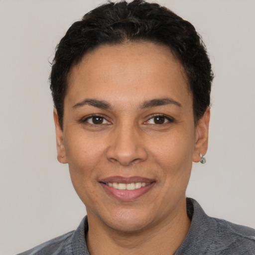 Joyful white adult female with short  black hair and brown eyes