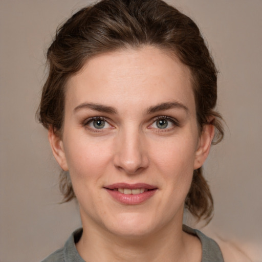 Joyful white young-adult female with medium  brown hair and grey eyes