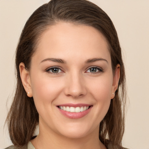 Joyful white young-adult female with long  brown hair and brown eyes