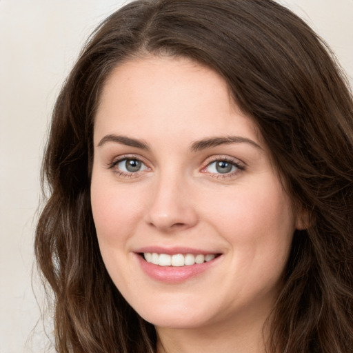 Joyful white young-adult female with long  brown hair and green eyes