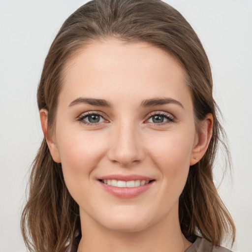 Joyful white young-adult female with medium  brown hair and grey eyes