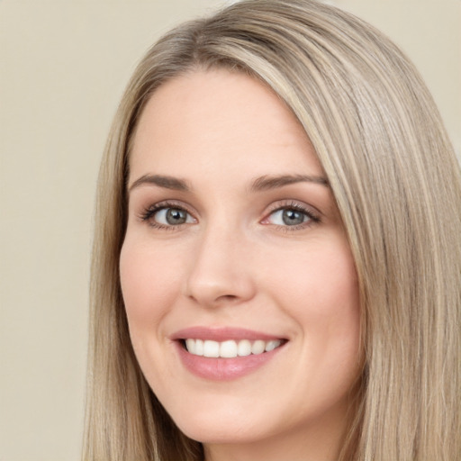 Joyful white young-adult female with long  brown hair and blue eyes