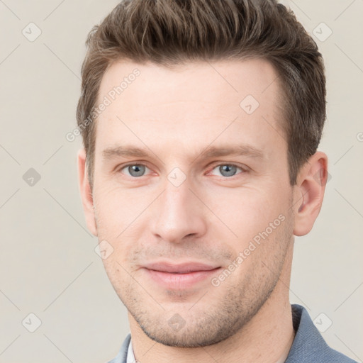 Joyful white young-adult male with short  brown hair and grey eyes