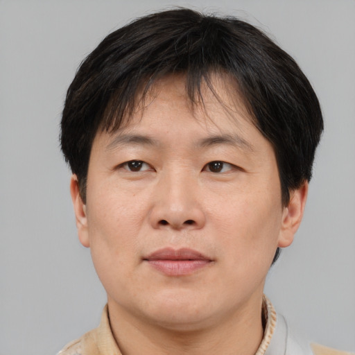 Joyful asian adult male with short  brown hair and brown eyes