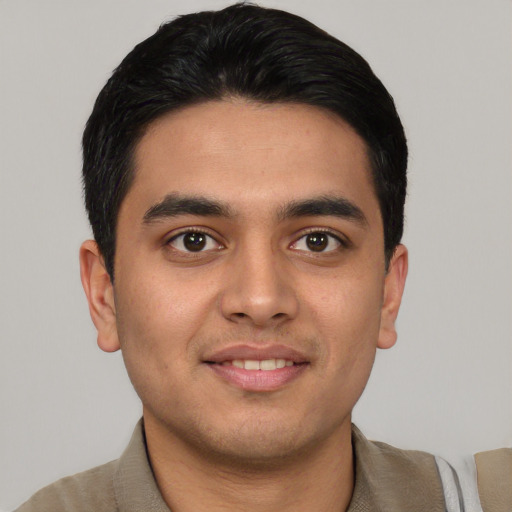 Joyful latino young-adult male with short  black hair and brown eyes