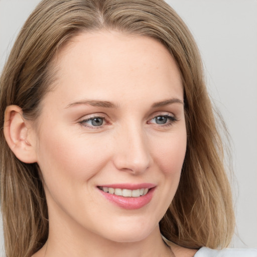 Joyful white young-adult female with long  brown hair and blue eyes