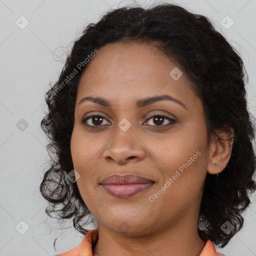 Joyful black young-adult female with long  brown hair and brown eyes