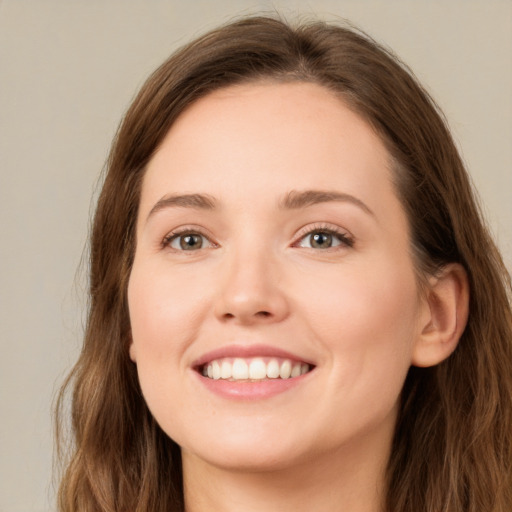 Joyful white young-adult female with long  brown hair and green eyes