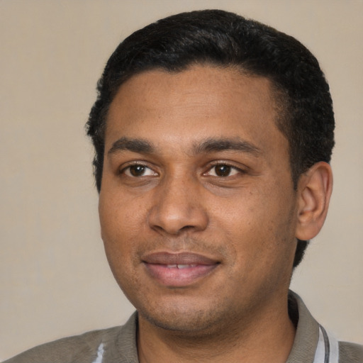 Joyful black young-adult male with short  black hair and brown eyes