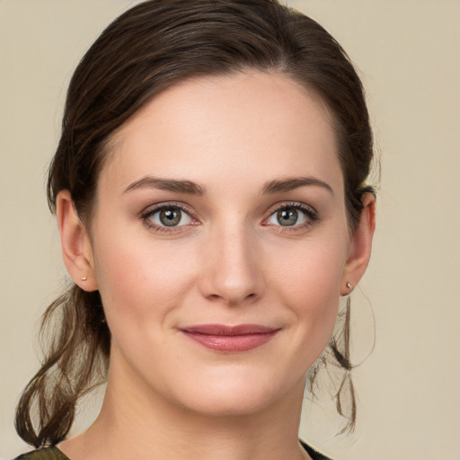 Joyful white young-adult female with medium  brown hair and green eyes