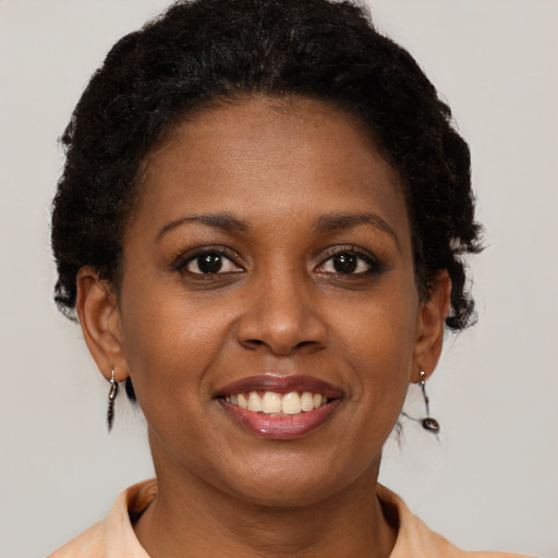 Joyful black young-adult female with short  brown hair and brown eyes