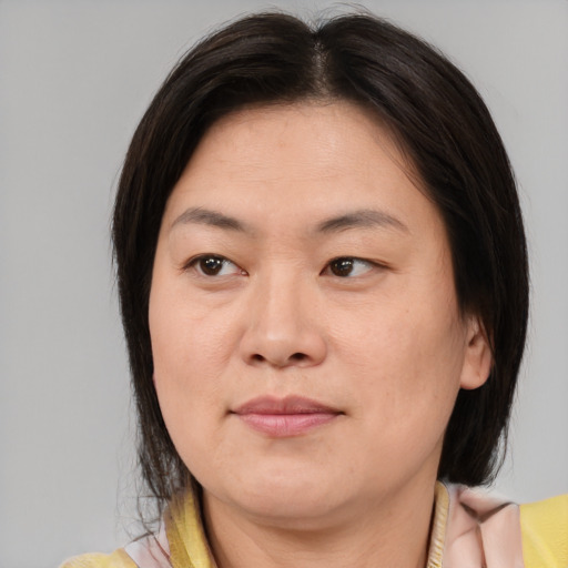 Joyful asian adult female with medium  brown hair and brown eyes