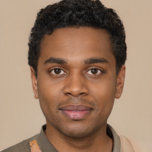 Joyful black young-adult male with short  black hair and brown eyes