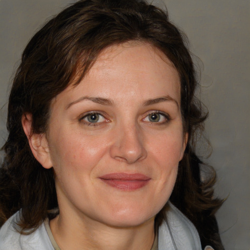 Joyful white adult female with medium  brown hair and blue eyes