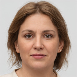 Joyful white adult female with medium  brown hair and grey eyes