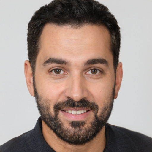 Joyful white adult male with short  black hair and brown eyes