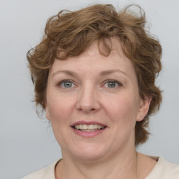 Joyful white adult female with medium  brown hair and blue eyes