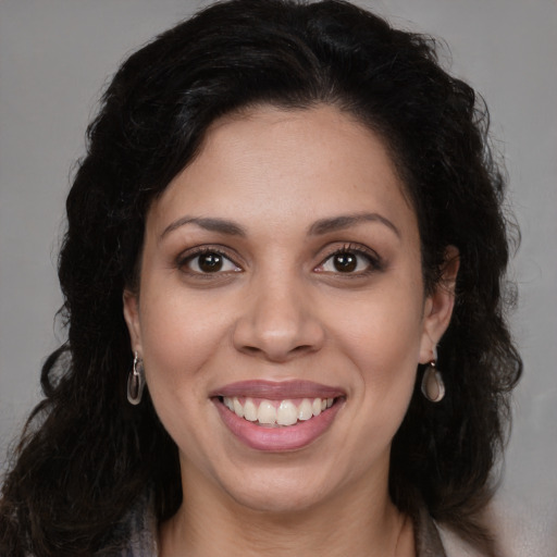 Joyful black young-adult female with long  brown hair and brown eyes