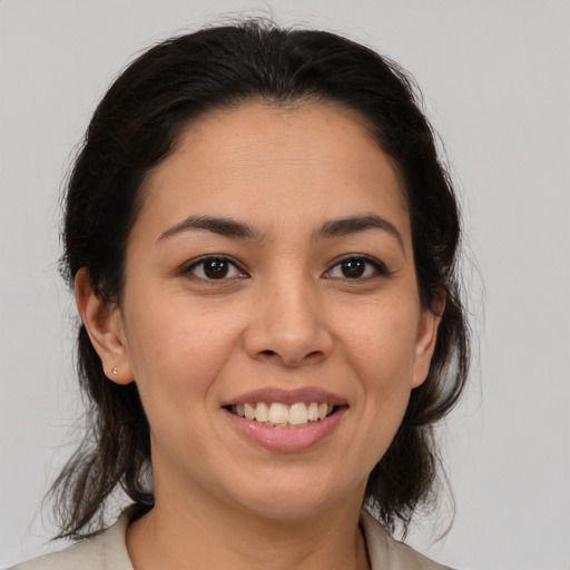 Joyful latino young-adult female with medium  brown hair and brown eyes