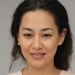 Joyful latino young-adult female with medium  brown hair and brown eyes