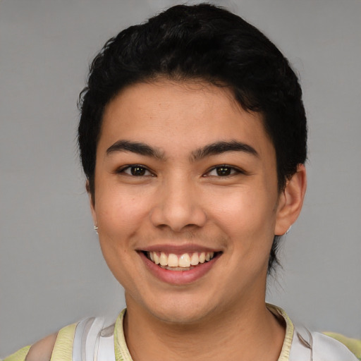 Joyful latino young-adult male with short  brown hair and brown eyes