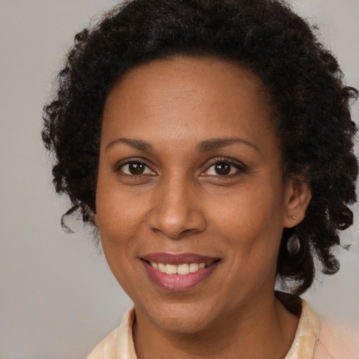 Joyful black adult female with medium  brown hair and brown eyes