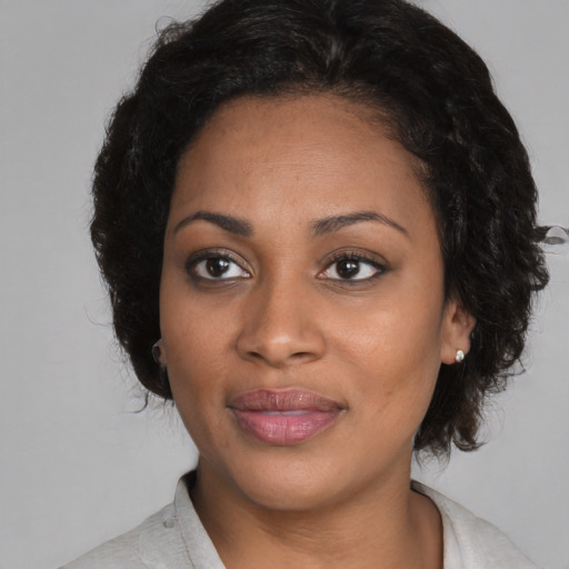 Joyful black adult female with medium  black hair and brown eyes
