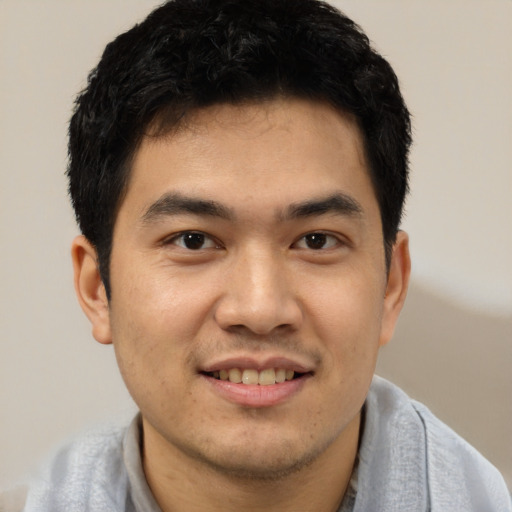 Joyful asian young-adult male with short  black hair and brown eyes