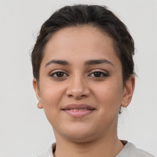 Joyful latino young-adult female with short  brown hair and brown eyes