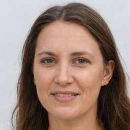 Joyful white adult female with long  brown hair and brown eyes