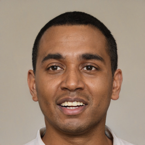 Joyful black young-adult male with short  black hair and brown eyes