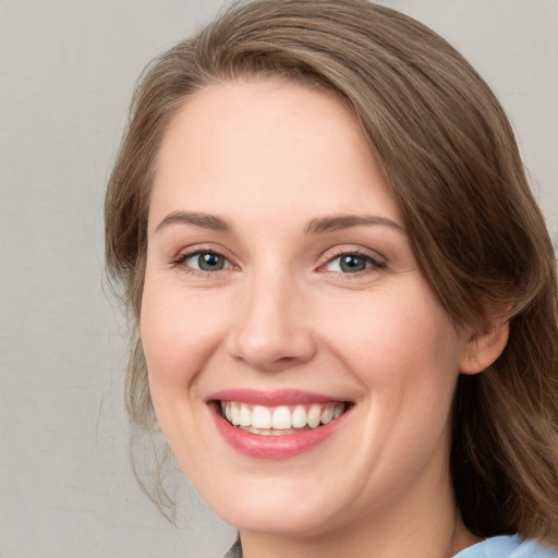 Joyful white young-adult female with medium  brown hair and blue eyes