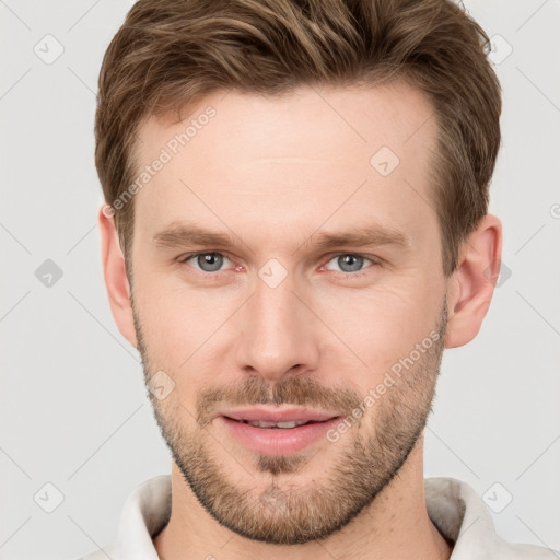 Joyful white young-adult male with short  brown hair and grey eyes