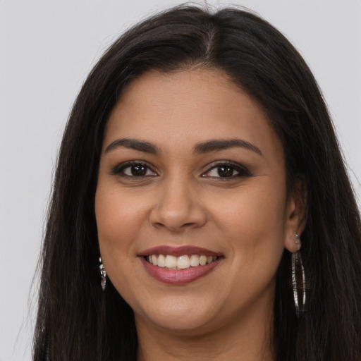 Joyful latino young-adult female with long  brown hair and brown eyes
