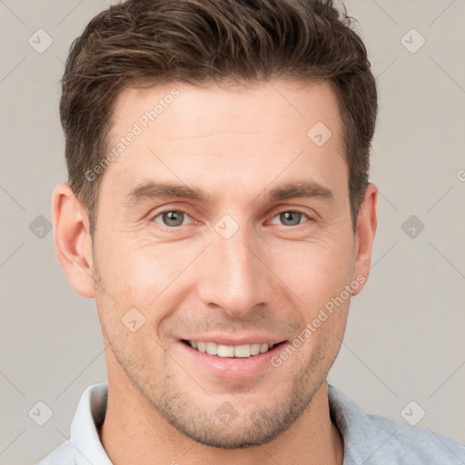 Joyful white young-adult male with short  brown hair and grey eyes