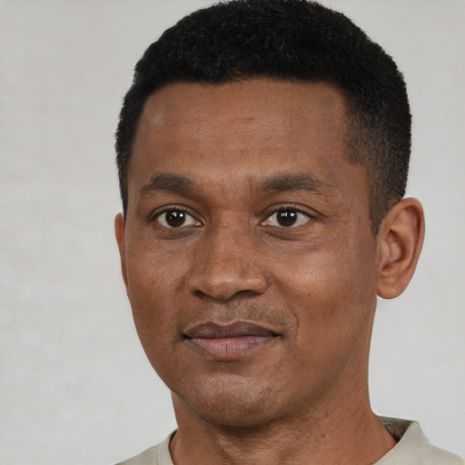 Joyful black adult male with short  brown hair and brown eyes