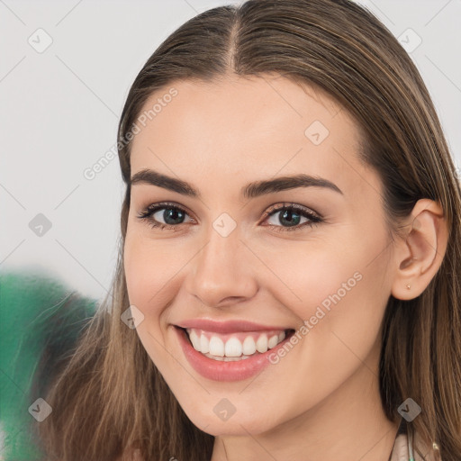 Joyful white young-adult female with long  brown hair and brown eyes